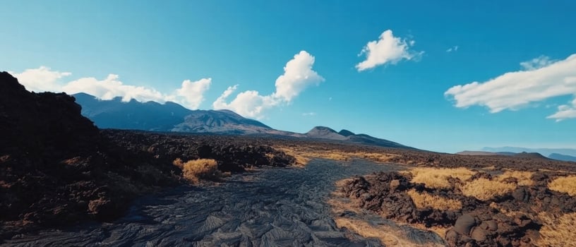 Volcanic landscape showcasing lava flows and ash fields under a clear blue sky photo