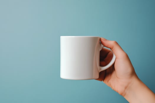 A person holding a white coffee mug on a blue background photo