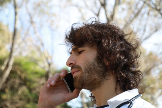 Long Hair Male Doctor Talks On The Phone Bad News Outside The Hospital Outdoor photo