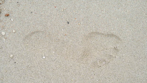 Above view of single footprints of people on the sandy beach. for background and textured of dry beach. photo