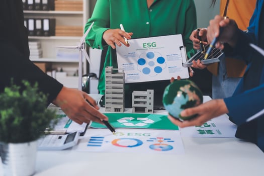 Business people working on a table with a green paper photo