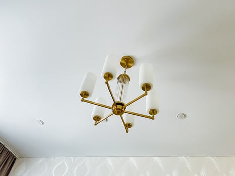 A stunning chandelier beautifully hangs from the ceiling, serving as a captivating focal point that truly enhances the rooms unique charm and elegance, drawing the eye of every observer photo