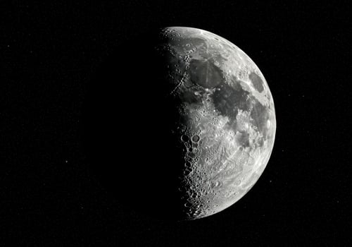The moon in its half-illuminated phase, showing craters and details against the dark backdrop. photo