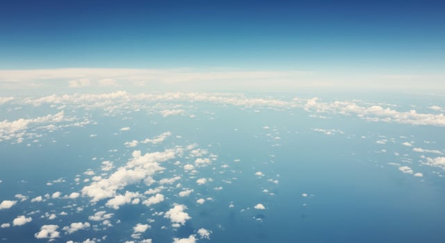 A beautiful aerial view showcasing fluffy clouds floating in a bright blue sky. photo
