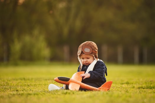 Focused ,view with ,,background. Little boy is playing with toy plane on the summer field photo