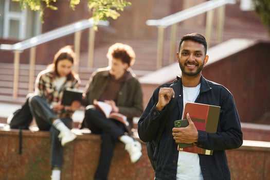 Positive Indian man. Young students ,in ,casual clothes are together outdoors photo