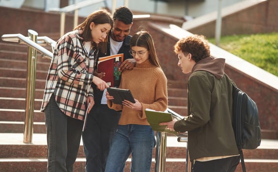 Hanging, out after lessons. Four young students in casual clothes are together outdoors photo