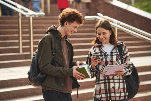 With, educational materials, notepad. Man and woman students are together outdoors near university photo