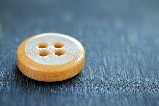 Button made of wood on blue surface photo