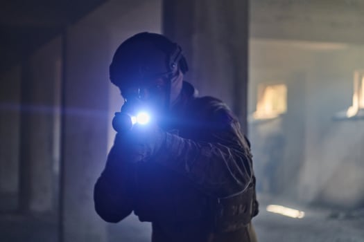 A professional soldier in an abandoned building shows courage and determination in a war campaign photo