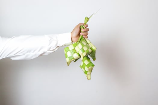 ketupat. gesture of muslim man hand hold rice cake photo