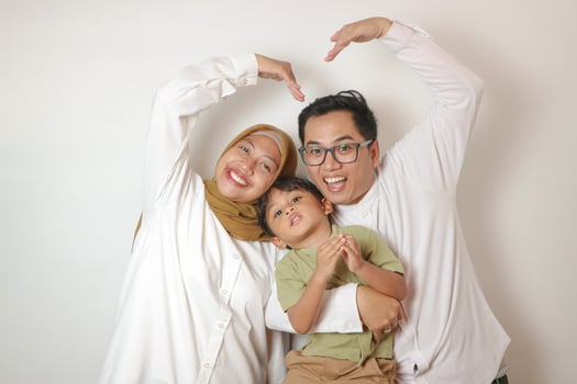 Happy young family shaping heart and love with hands photo