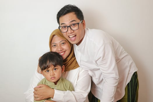 Muslim family of two adults and son showing greetings gesture isolated over white background photo