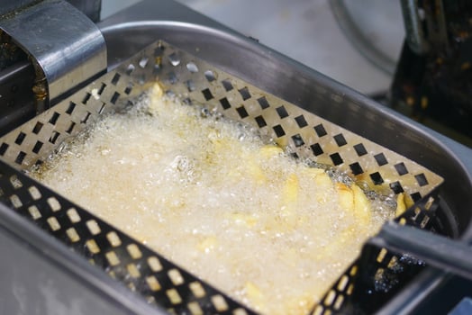 Fried potatoes cooking in hot oil in a small kitchen photo