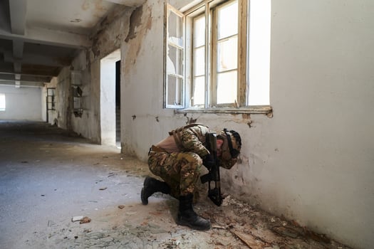 A professional soldier carries out a dangerous military mission in an abandoned building photo
