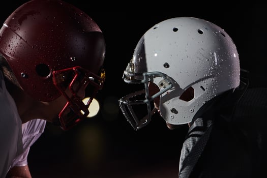 Two american football players face to face in silhouette shadow on white background photo
