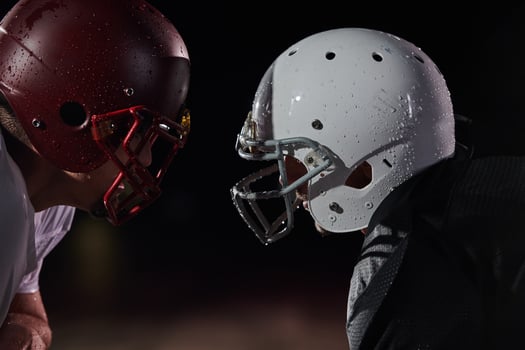 Two american football players face to face in silhouette shadow on white background photo