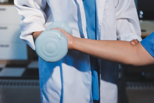 A doctor is holding a hand with a blue object photo