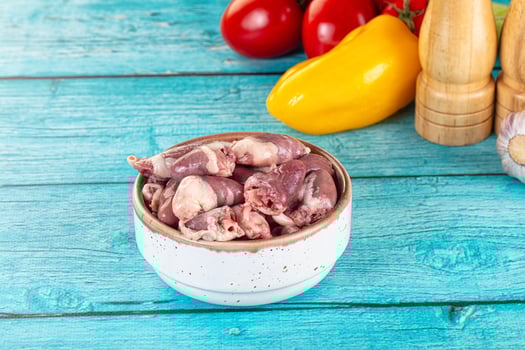 Raw chicken in a bowl on a blue table photo