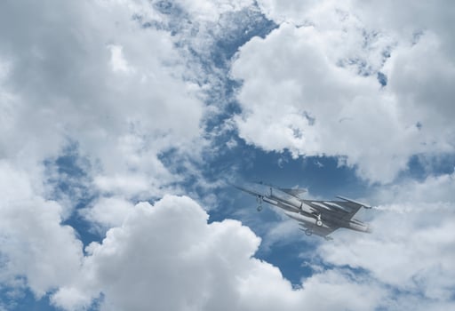 A fighter jet flying through the sky with clouds photo