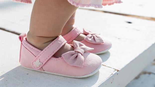 A close up of a baby's pink shoes photo