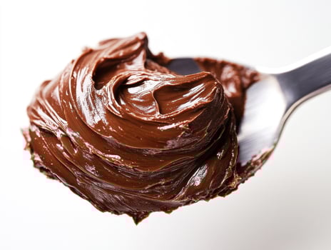 Rich chocolate spread on a spoon ready for a sweet treat photo