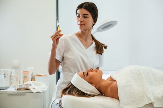 Getting ready for, injection. Woman face getting facial care by beautician hands at spa salon photo