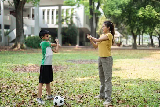 Exercise and Teamwork. A young boy and a woman stretching together before a soccer practice. photo