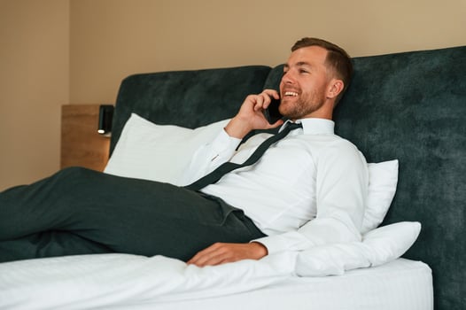 Talking by phone.. Businessman is indoors in the hotel room photo