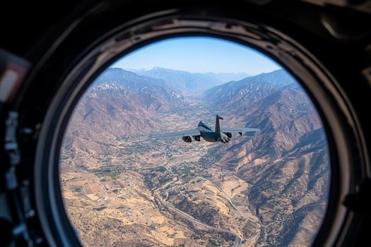 A fighter jet flying over mountains and valleys photo