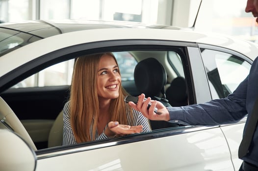 Trying, the interior. Man in formal clothes is with woman customer with the electric car photo