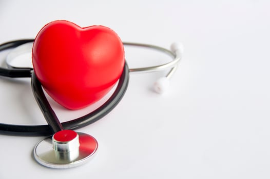 Close up view of stethoscope and a red heart shaped with customizable space for text. Medical and health concept photo