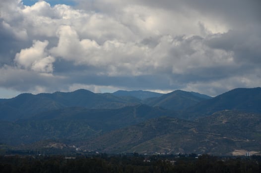 Majestic mountain landscape under dramatic clouds with hints of sunlight peeking through in the late afternoon photo