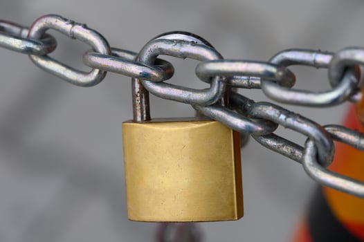 Locked securely, ensuring safety with a sturdy padlock on a chain link, representing protection in an urban environment photo