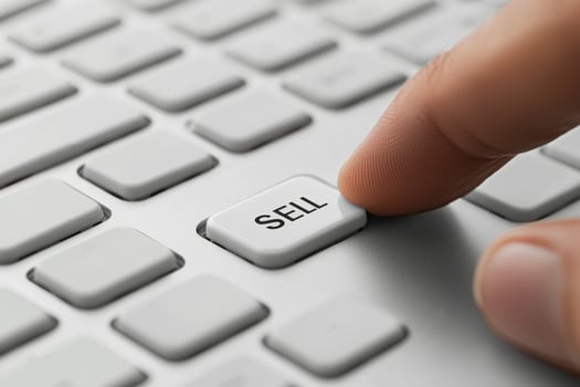 Finger presses white sell button on keyboard photo