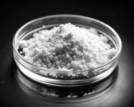 A bowl of white powder sitting on a black surface photo