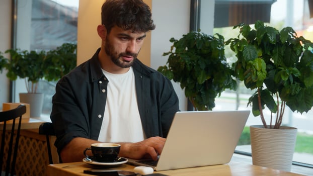 Caucasian man typing laptop desktop computer freelance online distant job work male guy businessman e-commerce client business student cafe restaurant studying entrepreneur visitor indoor order coffee photo