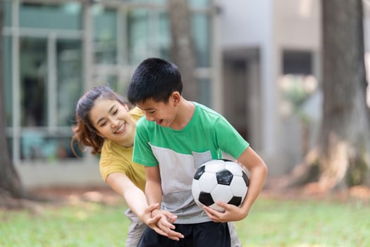 Joyful Interaction and Soccer. A girl encourages a boy while they enjoy a playful soccer game together. photo