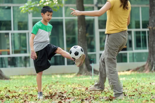 Childhood Exercise and Soccer Practice. A boy skillfully practices soccer with guidance from a girl. photo