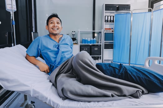 A man in a hospital bed smiling photo