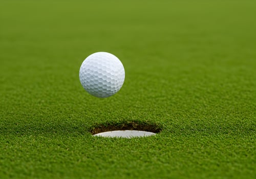 Golf Ball About to Sink into Hole on Green photo