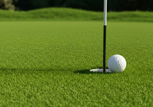 Golf Ball Near the Hole on a Lush Green Putting Green photo
