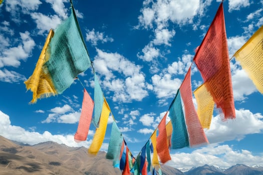 Colorful prayer flags waving in the wind over a mountain landscape photo
