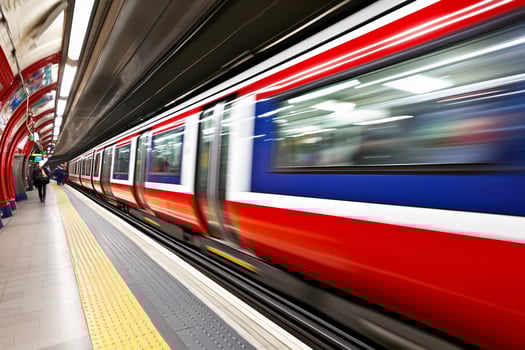 A red and white subway train is moving through a station photo