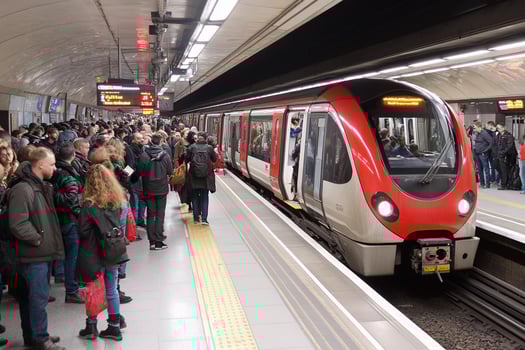 A red and white subway train pulling into a station photo