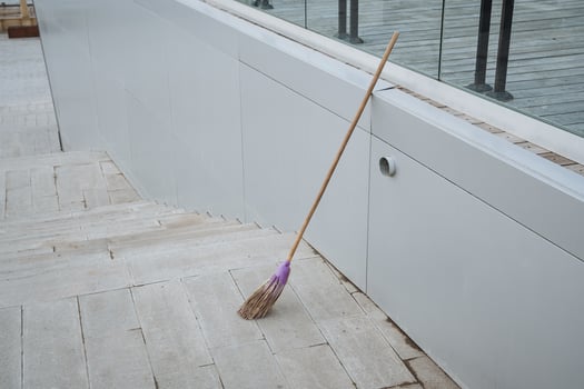 On a tiled floor, there is a broom that features a striking purple handle, making it a colorful addition to the household cleaning supplies that can be found in any home photo