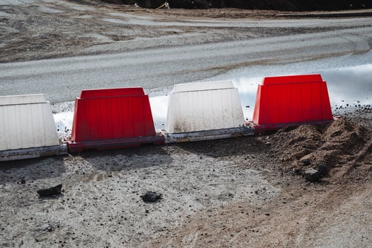 A row of red and white barriers on the side of a road photo