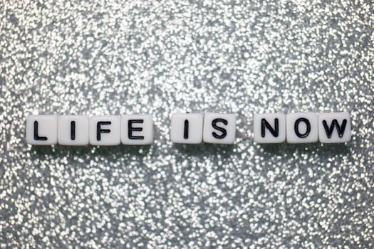 Motivational message displayed with black and white letter cubes on a sparkling silver background photo