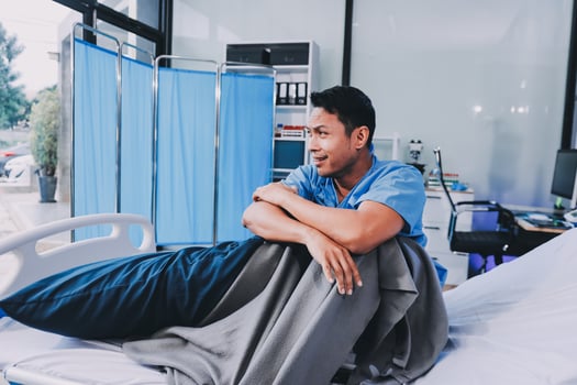 A male doctor sitting on a hospital bed photo