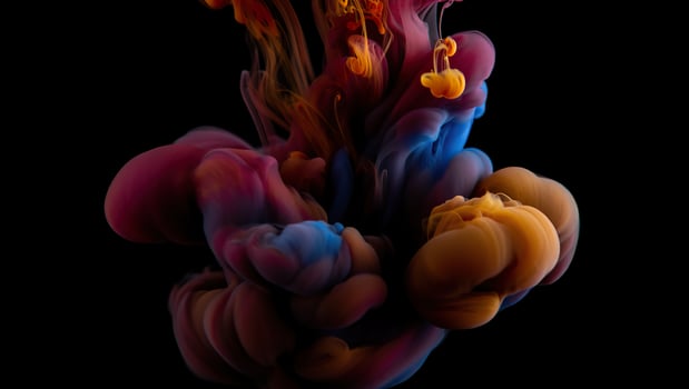 Colorful ink flowing into water on a black background photo